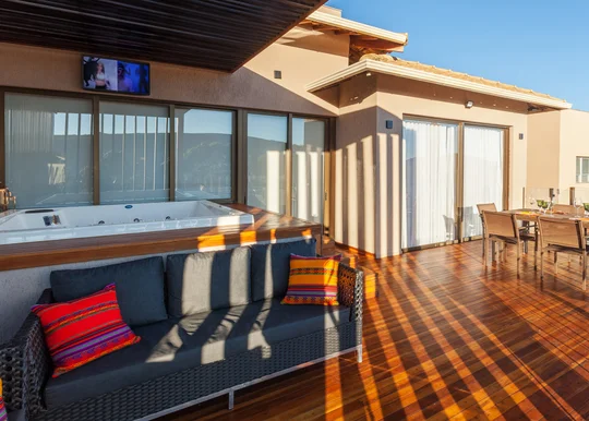 Terraza con pileta, deck de madera y vistas panorámicas al atardecer — proyecto CASA RR, por Frederico Bicalho Arquitetura