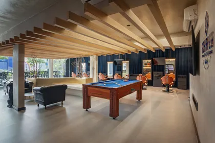 Galería moderna con techo de vigas de madera, mesa de billar y muebles negros — proyecto SCHAPER BARBEARIA, por Frederico Bicalho Arquitetura