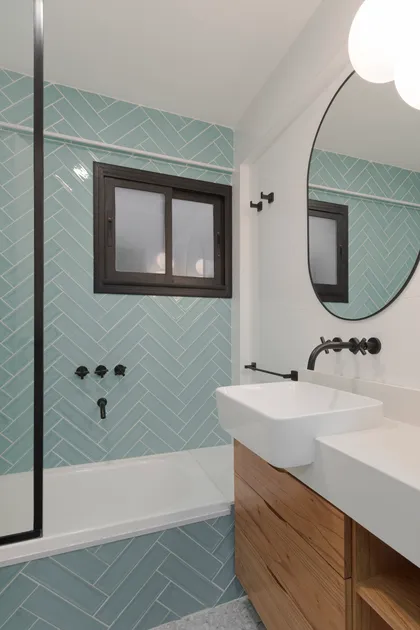 Baño moderno con detalles en madera y azulejos celestes — proyecto Obra Aguirre, por SYA Arquitectas, en Palermo