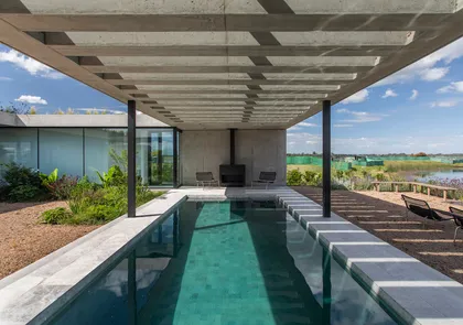 Pileta rectangular bajo pergola hormigon con vistas al campo abierto — proyecto CASA CONSERVATORIO, por GMARQ, en Belén de Escobar