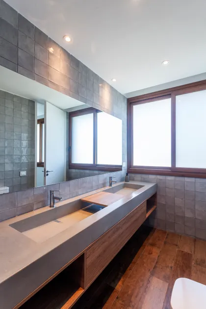 Baño moderno con doble lavabo de cemento y azulejos grises — proyecto Casa Green, por Frato construcciones , en Belén de Escobar