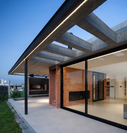 Fachada moderna con pérgola de hormigón y ladrillo visto — proyecto CASA BSB, por BUSCETTI & DI BERNARDO arquitectas, en Gonnet