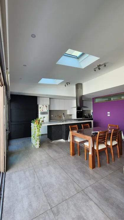 Cocina moderna de planta abierta con isla, comedor y tragaluces — proyecto Casa Berner, por Zima Arquitectura, en La Plata