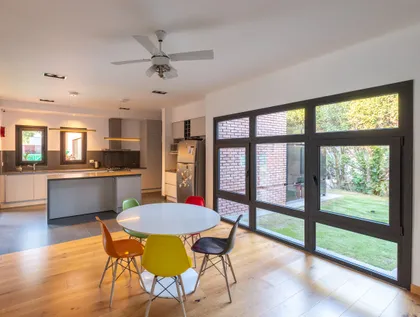 Comedor y cocina modernos de planta abierta con mucha luz natural — proyecto VIVIENDA L.L, por Lorenabusquetsarquitectura, en Córdoba