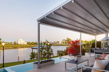 terraza moderna junto al agua con pérgola retráctil — proyecto TOLDER - PERGOLAS, por Argentina en Obra 2024, en Rincón de Milberg