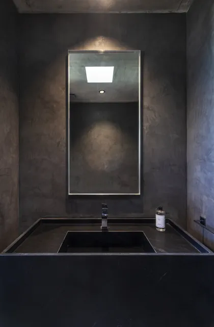 Baño moderno con paredes de microcemento y espejo rectangular — proyecto CASA FELIX, por GMARQ, en Pilar