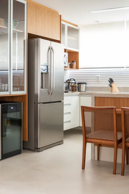 Cocina moderna con muebles madera, mesada blanca e isla con sillas de ratán — proyecto Apartamento Debski, por Felipe Lopes