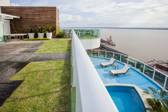 Terraza moderna con pileta, deck de madera y vistas al río — proyecto Cobertura LS, por Patrícia Marinho Arquitetura 
