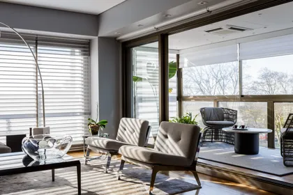 Living moderno con ventanales y sillones de contraste — proyecto Piso en Belgrano, por Gutman+Lehrer Arquitectas, en Belgrano