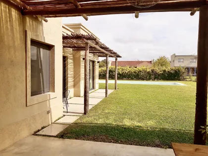 Galería techada con pérgola y ventanal al jardín con pileta — proyecto Santa Teresa 2, por Marconi Silva Arquitectos, en Benavidez