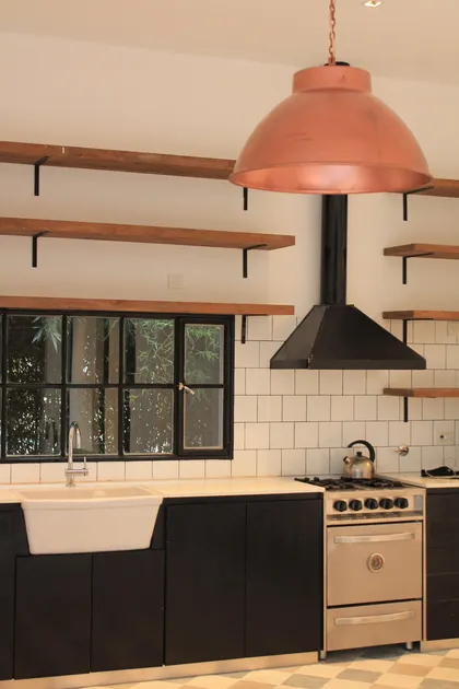 Cocina industrial moderna con campana cobre y alacenas negras — proyecto Casa Recodo, por Ronda Arquitectura, en Garin