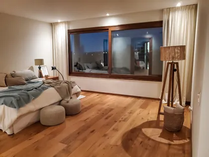 Dormitorio moderno con gran ventana y lámpara de pie — proyecto EL GOLF, NORDELTA , por Greschek Obras , en Nordelta