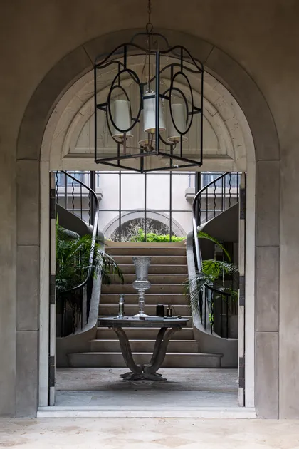 Entrada clasica con arco de piedra, escalera y lampara hierro negro — proyecto Casa Toscana , por Estudio Du