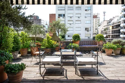 Terraza urbana con deck, muebles negros y plantas en macetas — proyecto Estudio Cerviño, por Estudio Du , en Palermo