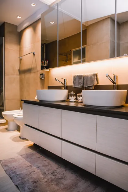 Baño moderno con doble vanitory blanco, espejos y pared beige — proyecto Cabrera, por Tali Estudio, en Palermo