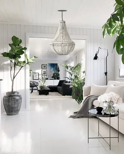 Sala de estar escandinava con plantas, lámpara de cuentas y muebles blancos — proyecto VICENTE LÓPEZ, por Estudio Cést Moi, en Vicente López