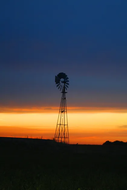 molino de viento al atardecer en campo rural — proyecto Proyecto Santa Maria, por Estudio Arruabarrena, en Rincón de Milberg