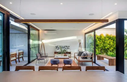 Living moderno con grandes ventanales y luz natural abundante — proyecto CASA J2M, por GMARQ, en Belén de Escobar