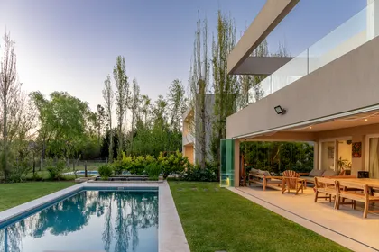 Casa moderna con piscina, patio y jardín exuberante — proyecto Campo grande III, por Juarez-Fevre Estudio de Arquitectura , en Buenos Aires