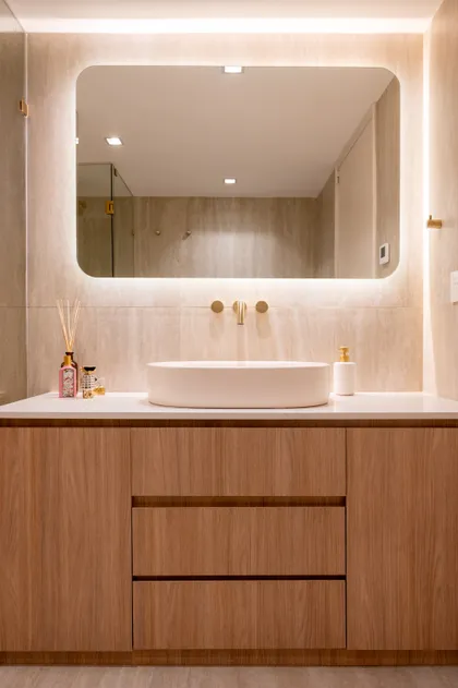 Baño moderno con lavabo de cerámica, mueble de madera y espejo redondo — proyecto ALVEAR TYM, por AB ARQUITECTURA, en Recoleta