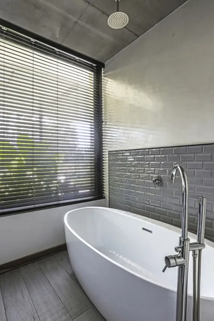 Baño moderno con bañera exenta y grifería de pie — proyecto Chacras de la Cruz 112, por KTAR