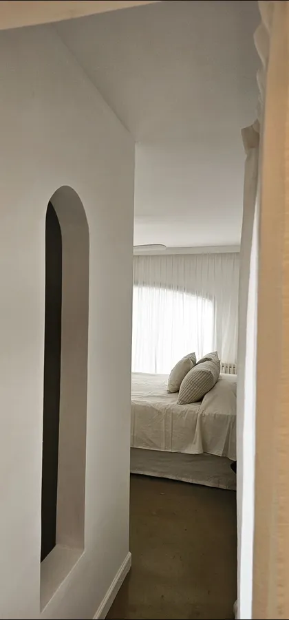 Dormitorio minimalista con cortinas blancas y nicho arqueado — proyecto Fatima , por Claraboia , en Pilar