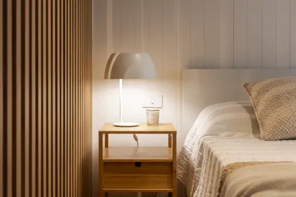 Dormitorio nórdico con pared de lamas de madera y lámpara moderna — proyecto REFORMA NE, por Rastro Estudio, en Palermo