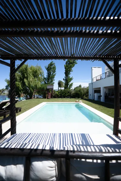 Piscina moderna bajo pérgola con muebles de exterior — proyecto Obra Fachada Nicole, por Arq. Lourdes Yarade Saravia, en Manzanares