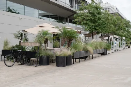 Terraza exterior moderna con vegetación exuberante — proyecto Croque Madame Puerto Madero, por Casa Cunia, en Buenos Aires