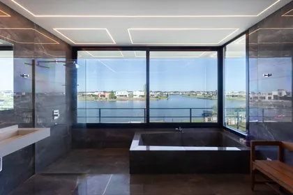 Baño moderno con vista al agua y bañera exenta de mármol — proyecto SS A7, Pilar, por ZUID PORT, en Pilar