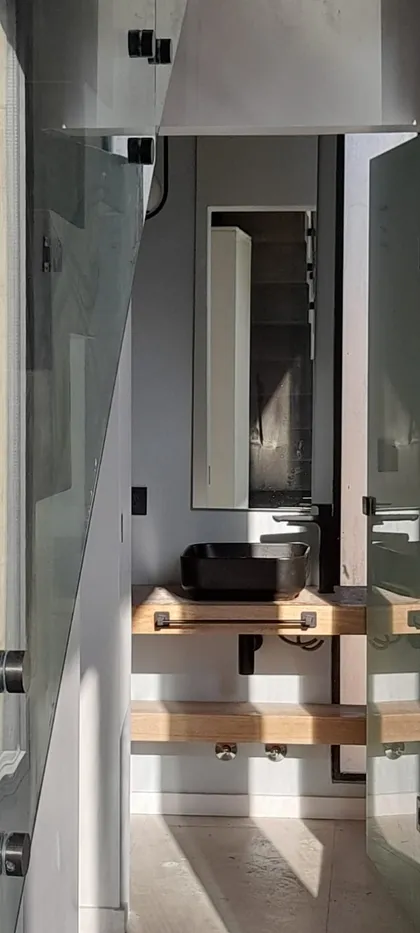 Baño moderno con vanitory flotante de madera y bacha negra — proyecto El 54, por Valeria Damiani Arquitecta, en Pilar