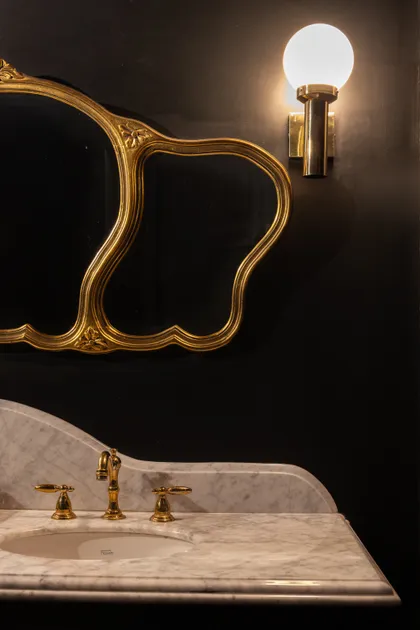 Baño con espejo dorado ornamentado y grifería de latón — proyecto PRESIDENTE BAR HIPODROMO, por AB ARQUITECTURA, en San Isidro