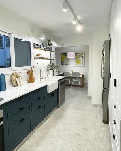 Cocina moderna con muebles azul oscuro, mesada de mármol y bacha de campo — proyecto Paraná, por JT ARQUITECTURA, en Buenos Aires