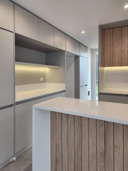 Cocina moderna con isla de madera y luces integradas — proyecto Acacias 265, por BARBALACO ARQUITECTOS, en Belén de Escobar