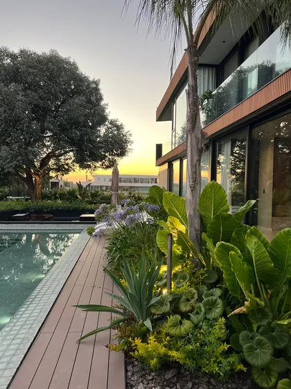 Impresionante jardín moderno con piscina y casa de lujo al atardecer — proyecto CAN., por Baires Green, en Canning