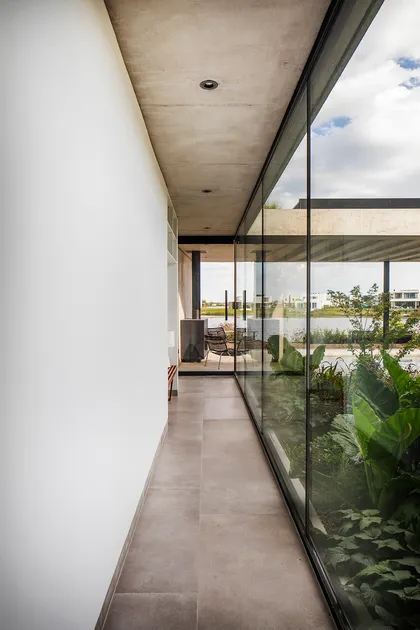 Galería moderna con ventanal y vistas al paisaje rural — proyecto CASA CONSERVATORIO, por GMARQ, en Belén de Escobar