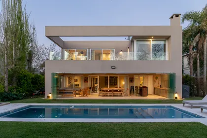 Fachada moderna con piscina y deck de madera — proyecto Campo grande III, por Juarez-Fevre Estudio de Arquitectura , en Buenos Aires