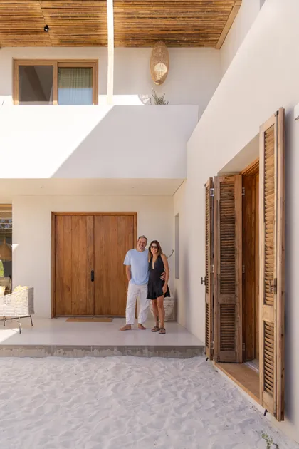 Fachada de villa mediterránea con puertas de madera y techo de bambú — proyecto El Refugio, por Grupo Pauta Arquitectura, en Pinamar