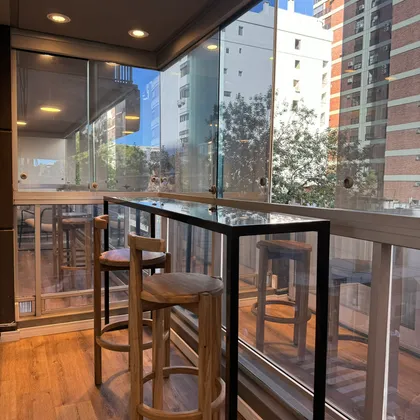 Balcón moderno con vista urbana y muebles de madera y metal — proyecto Salguero I, por MDBK Arquitectura, en Palermo