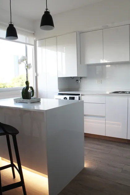 Cocina blanca minimalista con isla, piso madera y grandes ventanales — proyecto DEPTO OH, por Estudio Grupo 32, en Buenos Aires