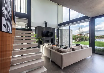 Living moderno con escalera flotante y grandes ventanales — proyecto Casa BJM, por Vanguarda Arquitectos, en Belén de Escobar