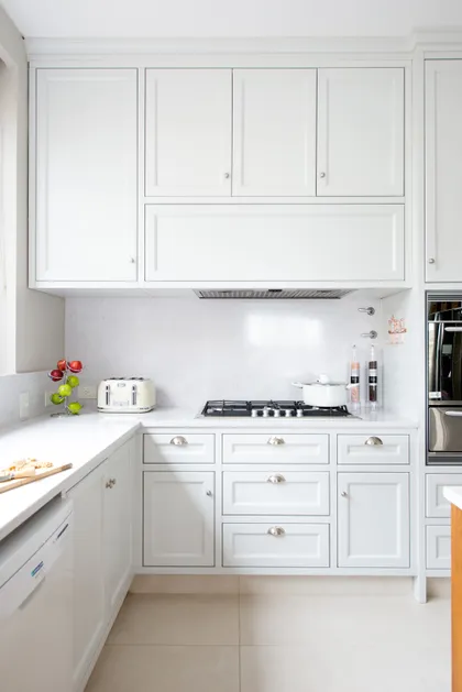 Cocina moderna blanca con gabinetes estilo shaker y mesadas de piedra — proyecto Casa MF, por Estudio Junor, en Belén de Escobar
