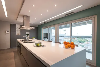 Cocina moderna con isla grande y pared verde vibrante — proyecto Cocinas, por Escalaveinte