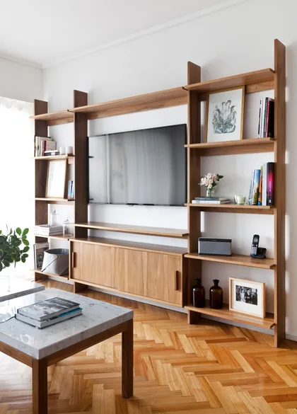 Living moderno con estantería modular de madera y suelo de espiga — proyecto Proyecto Alfaro, por URBANO estudio, en Martínez