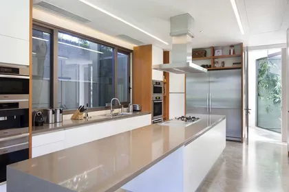Cocina moderna con isla grande y ventanales de piso a techo — proyecto Acasusso, por Remy Arquitectos, en Acassuso
