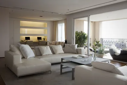Living moderno con sofá modular blanco y ventanales — proyecto Piso Barrio Parque, por LIVE IN by Brukman Chechik, en CABA