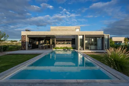 Casa moderna minimalista con piscina infinita y fachada de hormigón — proyecto Casa Tres Patios, por Besonías Almeida arquitectos, en Pilar