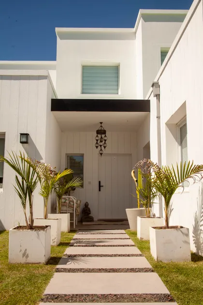 Fachada moderna con patio minimalista y plantas — proyecto Obra Fachada Nicole, por Arq. Lourdes Yarade Saravia, en Manzanares