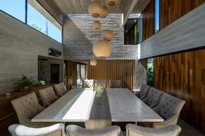 Comedor moderno industrial con mucha luz natural y detalles en madera y hormigón — proyecto Casa Leloir, por Besonías Almeida arquitectos, en Parque Leloir