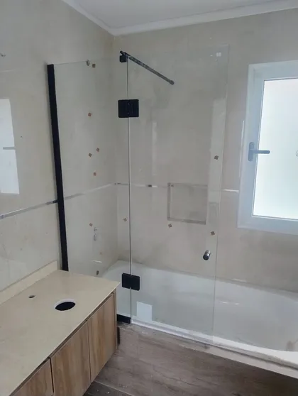 Baño moderno con bañera exenta y vanitory de madera — proyecto Mampara paño fijo + rebatible , por Cristalcenter, en Belén de Escobar